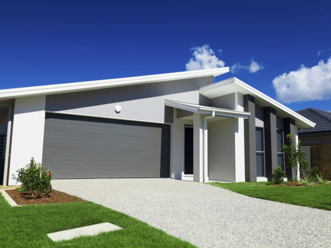 New suburban Australian house with small SOLD sign.